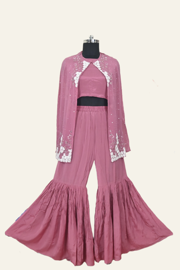 Butter Crepe suit set comprising a cape jacket with floral motifs, a flared leg pant and a blouse. Embellishments include sequins, Cutdana and Dabka work